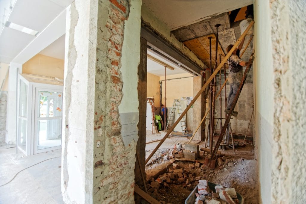Everything about Condominiums. The image depicts two men working on a building.