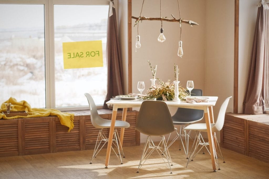 Mais-valias – Tudo o que Precisa Saber – imagem de uma sala de estar com janela para o exterior com um letreiro onde está escrito “For Sale”.