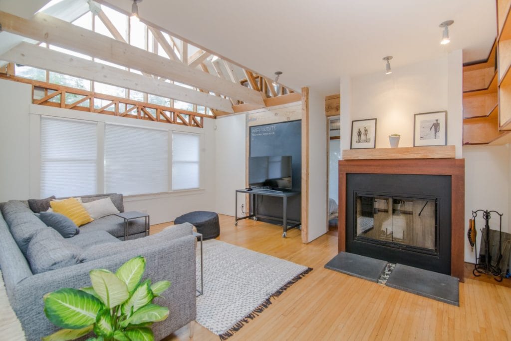 What is the Euribor rate? – Image of the interior of a house, depicting a living room with a central fireplace, a grey sofa, and a television in the background.