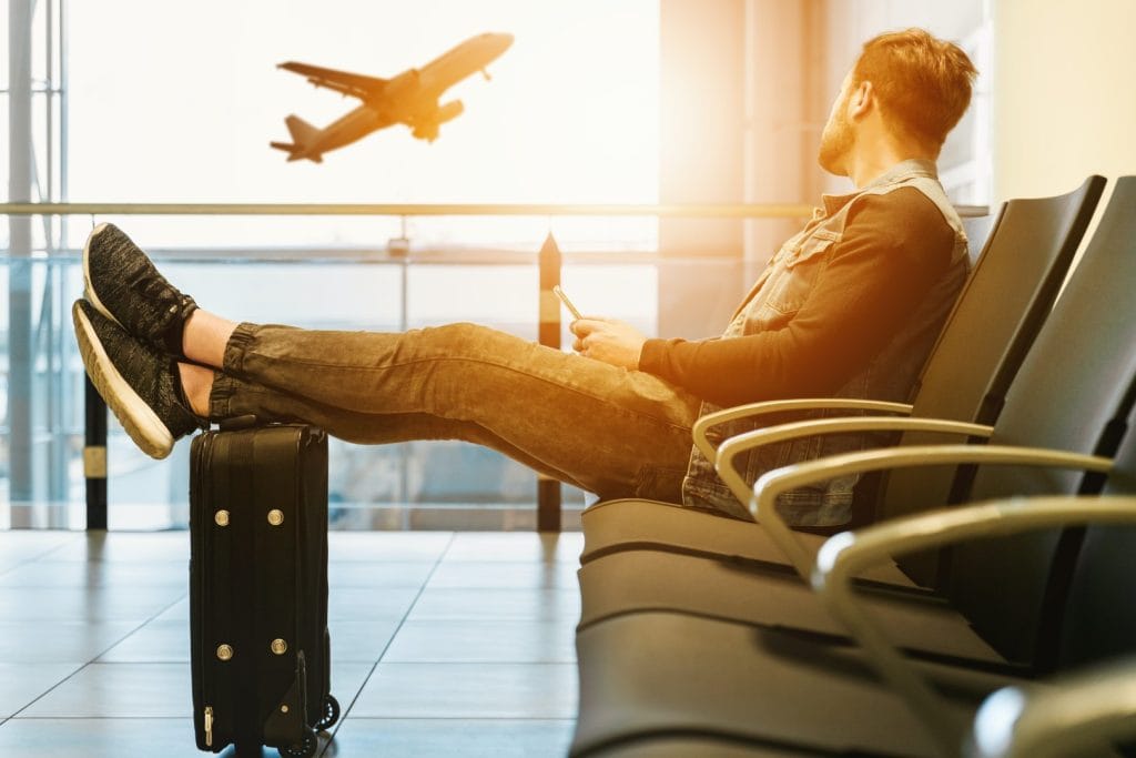 image from the article “D8 Visa for Digital Nomads 2026”. The image shows a digital nomad sitting at an airport, waiting for their flight.