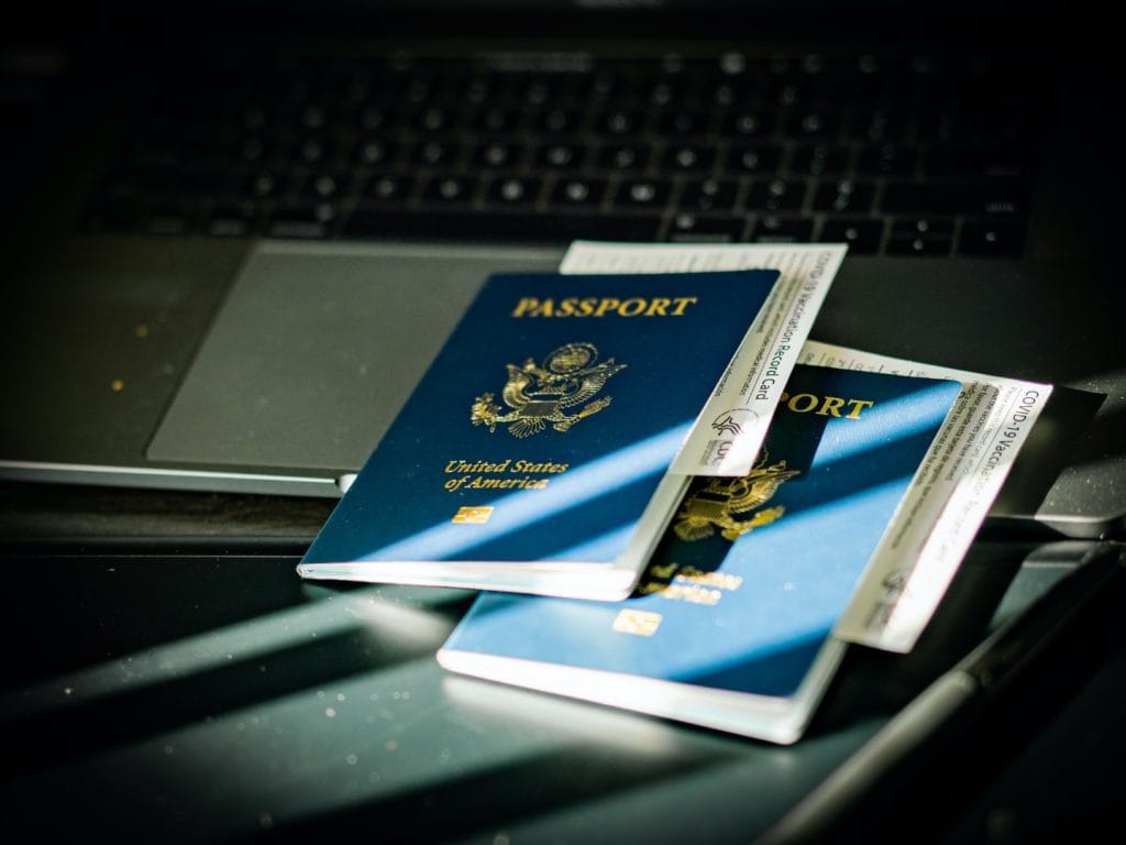 image from the article “D8 Visa for Digital Nomads 2026”. The image shows two United States passports resting on a laptop.