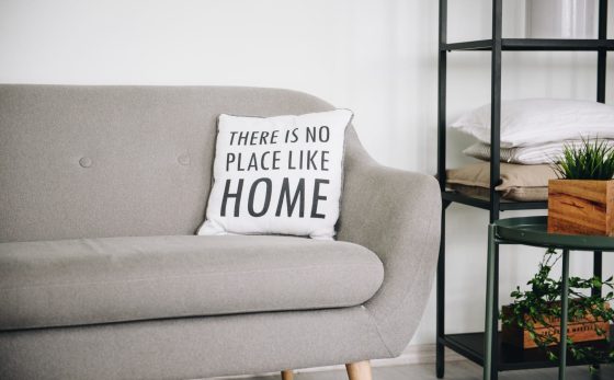 article cover image: Measures of the Mais Habitação package. A grey sofa and a cushion with the words "There is no place like home" can be seen in the image.