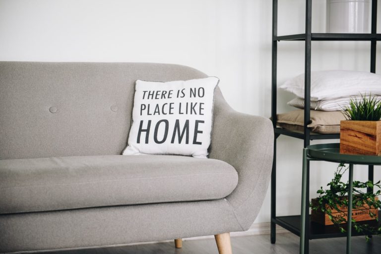 article cover image: Measures of the Mais Habitação package. A grey sofa and a cushion with the words "There is no place like home" can be seen in the image.