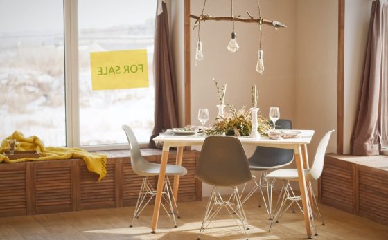 Cover image of the article: Capital Gains tax - Everything You Need to Know - an image of a living room with a window to the outside with a sign saying "For Sale".